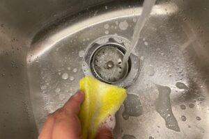 水を流しながらシンクの排水口まわりを洗うところ